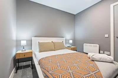 a bedroom with a large bed and two night stands at 2 Bed, 2 Bath New Build Apartment next to Albert Dock Liverpool & M&S Bank Arena - With Juliet Balcony - Monarchs Quay Arena Apartments - Close to Liverpool ONE Shopping, Exhibition Centre Liverpool, Pullman Hotel, Bars & Restaurants in Liverpool