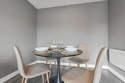 a dining room with a black table and chairs at 2 Bed, 2 Bath New Build Apartment next to Albert Dock Liverpool & M&S Bank Arena - With Juliet Balcony - Monarchs Quay Arena Apartments - Close to Liverpool ONE Shopping, Exhibition Centre Liverpool, Pullman Hotel, Bars & Restaurants in Liverpool