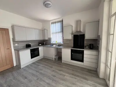 a large kitchen with white cabinets and a sink at 6 bedroom house with Riverviews - Free parking in Preston