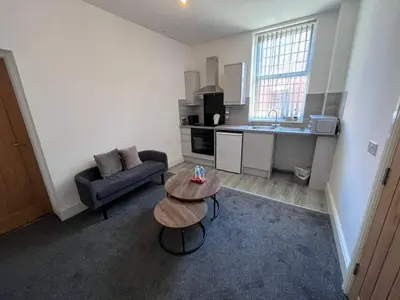a small living room with a table and a couch at 6 bedroom house with Riverviews - Free parking in Preston