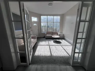 a living room with a couch and a window at 6 bedroom house with Riverviews - Free parking in Preston