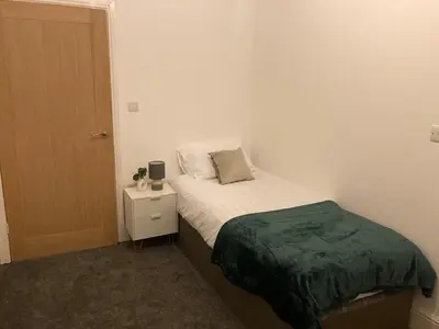 a small bedroom with a bed and a night stand at 6 bedroom house with Riverviews - Free parking in Preston