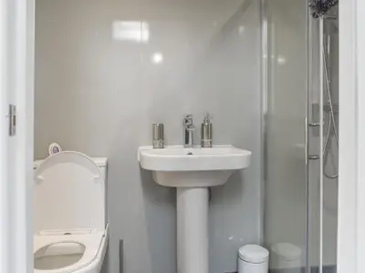 a bathroom with a sink and a toilet and a shower at Madeline Cottage in Clitheroe