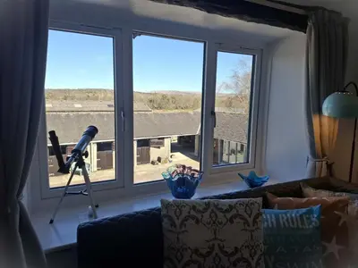 a living room with a large window and a microphone at The Coach House, Yealand Redmayne perfect for a family in a rural setting, bring your dogs and horse in Beetham