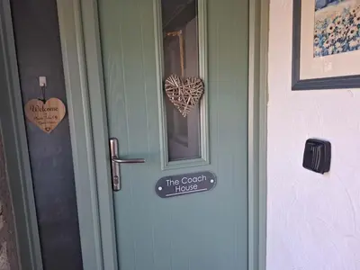 a door with a sign that reads the great house at The Coach House, Yealand Redmayne perfect for a family in a rural setting, bring your dogs and horse in Beetham