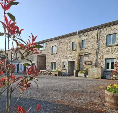 a large stone building with a courtyard in front at The Coach House, Yealand Redmayne perfect for a family in a rural setting, bring your dogs and horse in Beetham