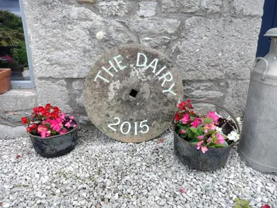 a stone sign that says the blazers with flowers in buckets at The Dairy, Yealand Redmayne in a rural setting, bring your dogs and horse in Beetham