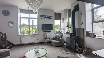 a living room with a couch and a tv at The Dairy, Yealand Redmayne in a rural setting, bring your dogs and horse in Beetham