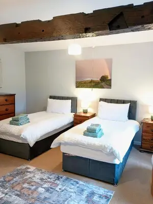 two beds sitting in a room with at The Old Farmhouse, Yealand Redmayne, a characterful cottage in a rural setting in Beetham