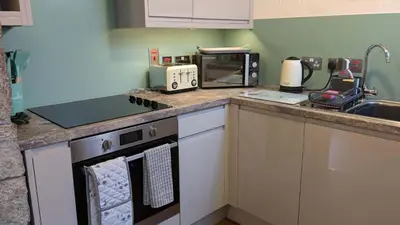 a kitchen with a counter top with a stove and a microwave at Corner Cottage, Yealand Redmayne, ideal family holiday, meet the resident animals in Beetham