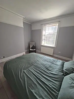 a bedroom with a large green bed in it at Holly House in Liverpool