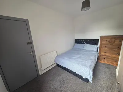 a small bedroom with a bed and a dresser at 61 coniston street next to anfield street in Liverpool