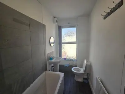 a bathroom with a tub and a toilet and a window at 61 coniston street next to anfield street in Liverpool