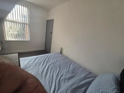 an empty bedroom with a bed and a window at 61 coniston street next to anfield street in Liverpool