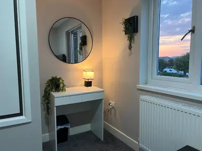 a bathroom with a mirror and a sink and a window at Stylish 2BR Stay- Preston City in Preston