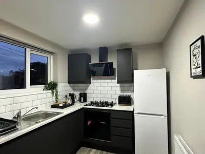 a kitchen with a white refrigerator and a sink at Stylish 2BR Stay- Preston City in Preston