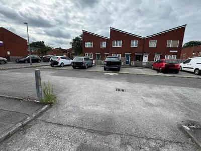 a parking lot with cars parked in front of a building at Stylish 2BR Stay- Preston City in Preston