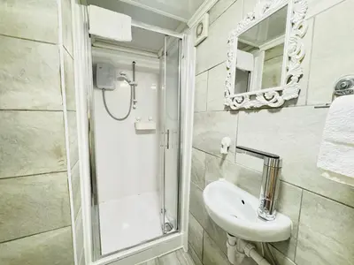 a white bathroom with a shower and a sink at Bold Street Studio I in Liverpool