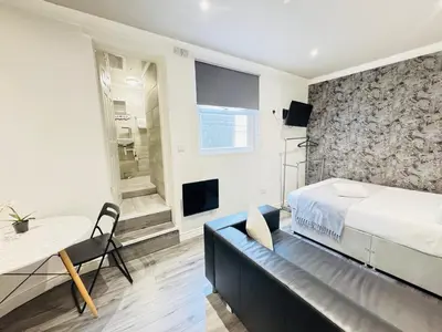 a bedroom with a bed and a table and a television at Bold Street Studio I in Liverpool
