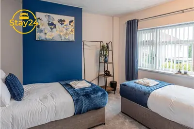 a bedroom with two beds and a window at Surrey Suite in Wallasey