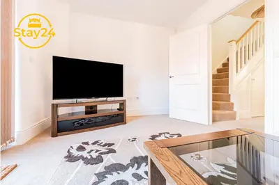 a living room with a television and a table at Surrey Suite in Wallasey
