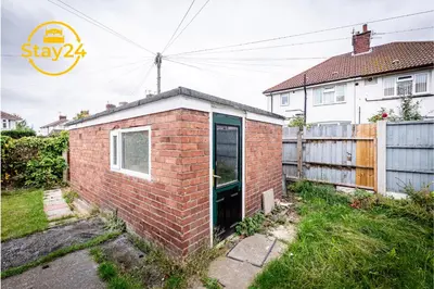 a brick house with a door in a yard at Surrey Suite in Wallasey