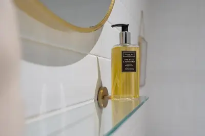 a bottle of soap on a shelf next to a mirror at Luxury Liverpool City Centre Apartment with Balcony, Sleeps 8, Near Liverpool ONE and Royal Albert Docks in Liverpool