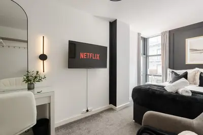 a bedroom with a bed and a tv on the wall at Luxury Liverpool City Centre Apartment with Balcony, Sleeps 8, Near Liverpool ONE and Royal Albert Docks in Liverpool
