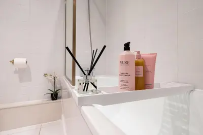 a bathroom with a shelf with a bottle ofmetics at Luxury Liverpool City Centre Apartment with Balcony, Sleeps 8, Near Liverpool ONE and Royal Albert Docks in Liverpool