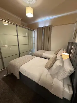 a bedroom with two beds and a mirror at Comfy Stay Near City & Station in Preston