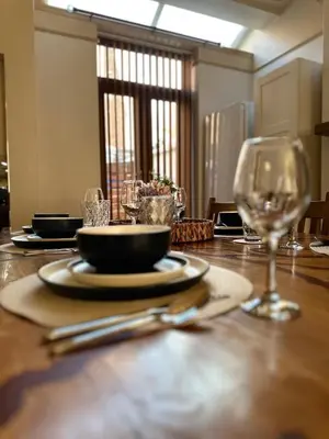 a table with plates and a glass of wine on it at Comfy Stay Near City & Station in Preston