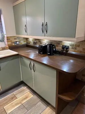 a kitchen with white cabinets with a camera on the counter at Comfy Stay Near City & Station in Preston