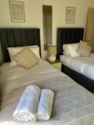two towels sitting on a bed in a bedroom at Comfy Stay Near City & Station in Preston