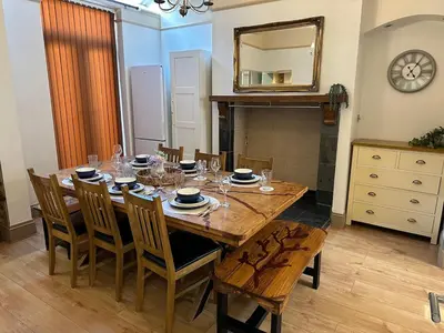 a dining room with a table with chairs and a mirror at Comfy Stay Near City & Station in Preston
