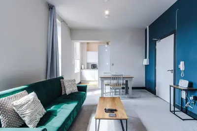 a living room with a green couch and a table at Bright Flat with Wifi, Close to Beach! in Wallasey