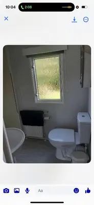 a bathroom with a toilet and a sink and a window at the mountain view in Millom