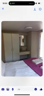 a bedroom with a large white bed with a cabinet at the mountain view in Millom