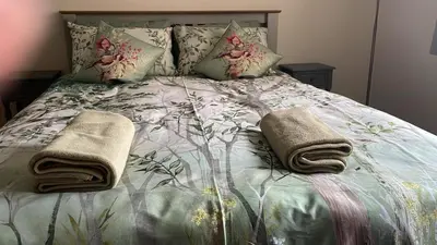 a bed with two towels and pillows on it at The Rookery Sandside - Luxury Coastal Home South Lake District and Beaches