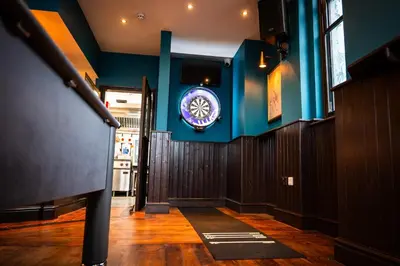 a hallway with a blue wall with a clock on it at The Royal Alfred - Opposite Central Train Station in Saint Helens