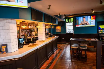 a bar in a pub with a tv on the wall at The Royal Alfred - Opposite Central Train Station in Saint Helens