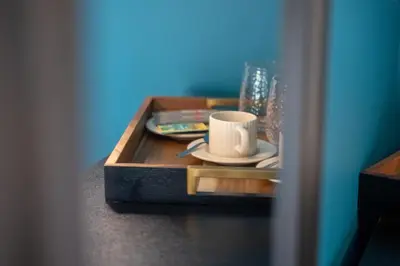 a coffee table with a coffee cup and a book at The Royal Alfred - Opposite Central Train Station in Saint Helens