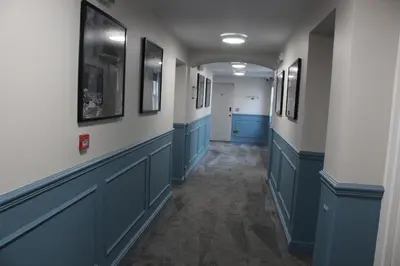 a hallway with blue cabinets and pictures on the walls at The Royal Alfred - Opposite Central Train Station in Saint Helens