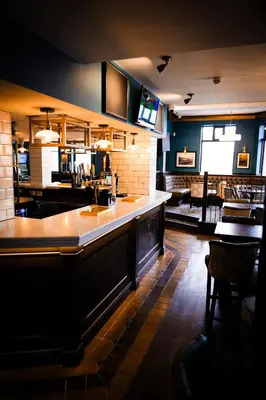a bar in a restaurant with a counter at The Royal Alfred - Opposite Central Train Station in Saint Helens
