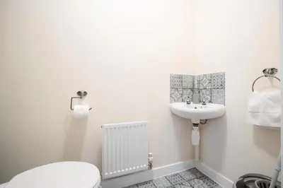 a white bathroom with a sink and a toilet at 2 Bedroom Home with Garden and Free Parking in Litherland
