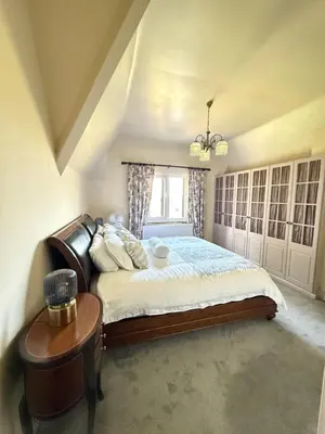 a bedroom with a bed and a table and a window at Grange Cottage in Belmont