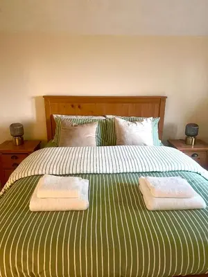 a bed with two towels on top of it at Grange Cottage in Belmont