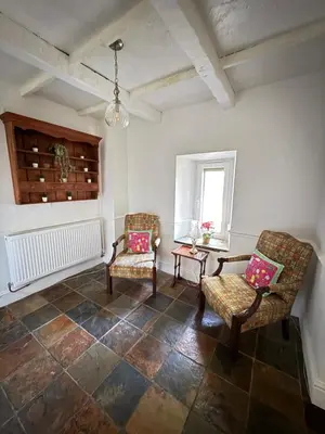 a room with two chairs and a table and a window at Grange Cottage in Belmont