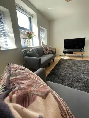 a living room with a couch and a flat screen tv at High Street Apartment in Garstang