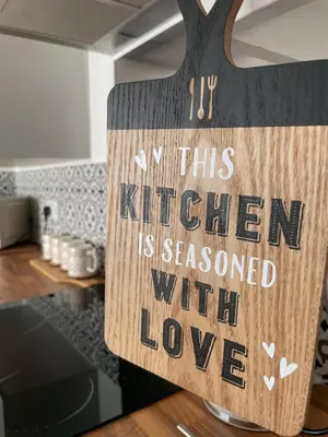 a sign that says in this kitchen is seasoned with love at High Street Apartment in Garstang