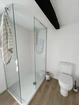 a bathroom with a toilet and a glass shower at High Street Apartment in Garstang